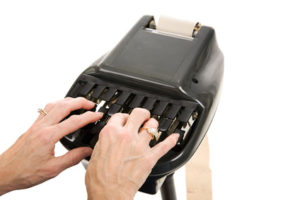 Closeup of a court reporters hands typing on a stenograph machine. Isolated on white background.
